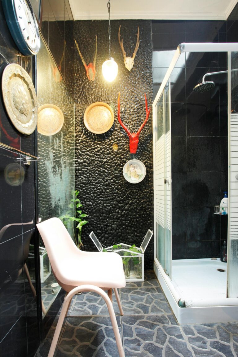 Modern bathroom with black walls and decorative antlers in Jakarta, Indonesia.